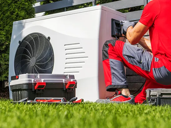 Worker repairing water heater outside.